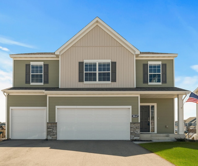 20147 79th Ave, Corcoran, MN 55340 - view of front of house featuring an attached garage, concrete driveway, stone siding, and a shingled roof