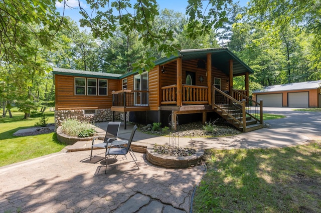 26952 Alpha Ln, Center Twp, MN 56465 - chalet / cabin with log veneer siding, a garage, an outdoor structure, a metal roof, and stairs