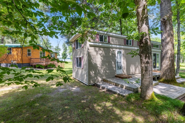 26952 Alpha Ln, Center Twp, MN 56465 - view of side of home featuring a wooden deck and a lawn