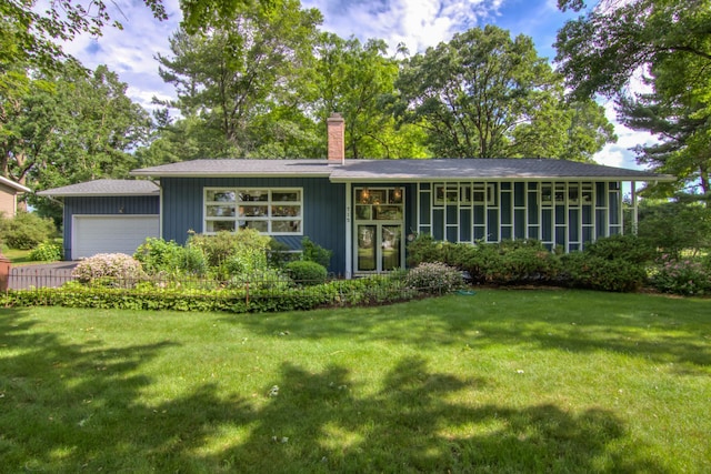 715 River Heights Rd SW, Menomonie, WI 54751 - view of front facade featuring a chimney, a front lawn, and an attached garage