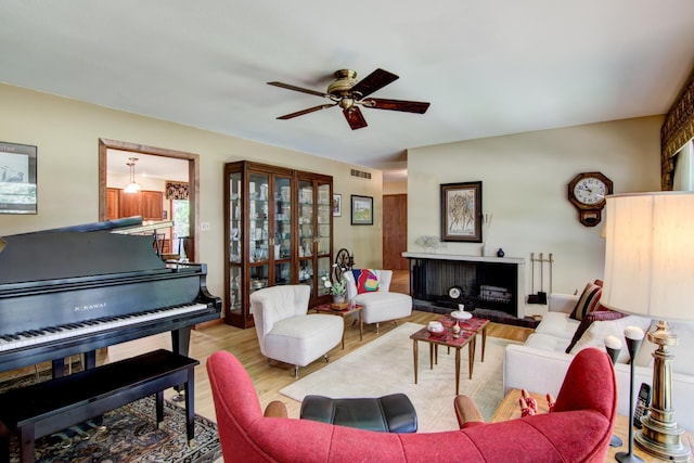 715 River Heights Rd SW, Menomonie, WI 54751 - living room featuring a ceiling fan, wood finished floors, and a fireplace with raised hearth
