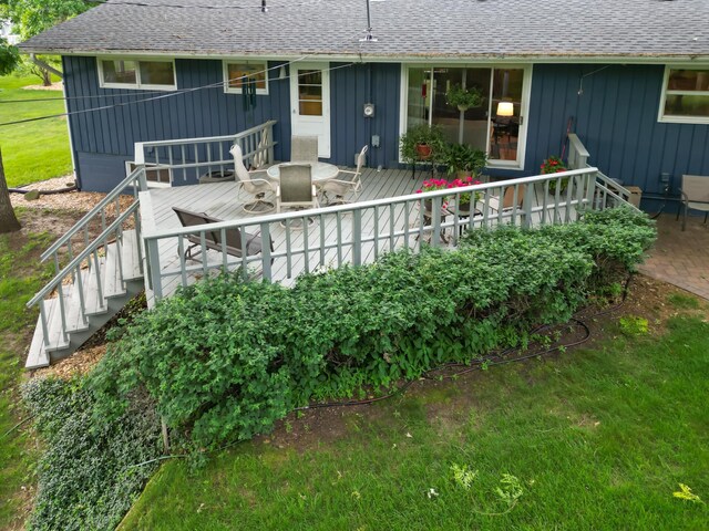 715 River Heights Rd SW, Menomonie, WI 54751 - back of property with a wooden deck, roof with shingles, outdoor dining space, and stairs