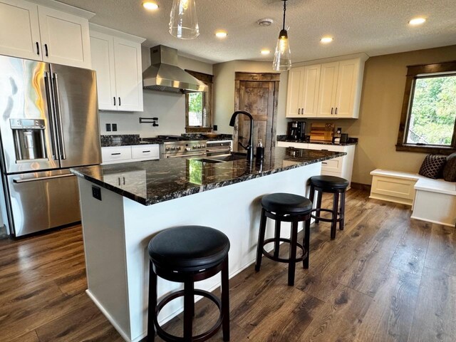 8766 Interlachen Rd, Lake Shore, MN 56468 - kitchen with premium appliances, wall chimney exhaust hood, healthy amount of natural light, white cabinets, and recessed lighting