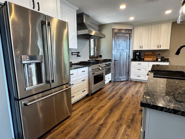8766 Interlachen Rd, Lake Shore, MN 56468 - kitchen with high end appliances, wall chimney exhaust hood, white cabinetry, dark wood-type flooring, and recessed lighting