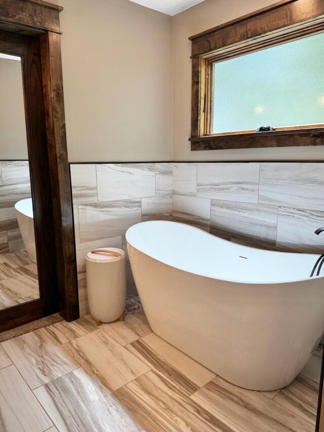 8766 Interlachen Rd, Lake Shore, MN 56468 - bathroom with a freestanding tub, tile walls, and a wainscoted wall