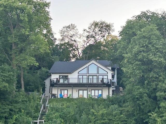 8766 Interlachen Rd, Lake Shore, MN 56468 - rear view of house featuring view of scattered trees, stairway, and a balcony