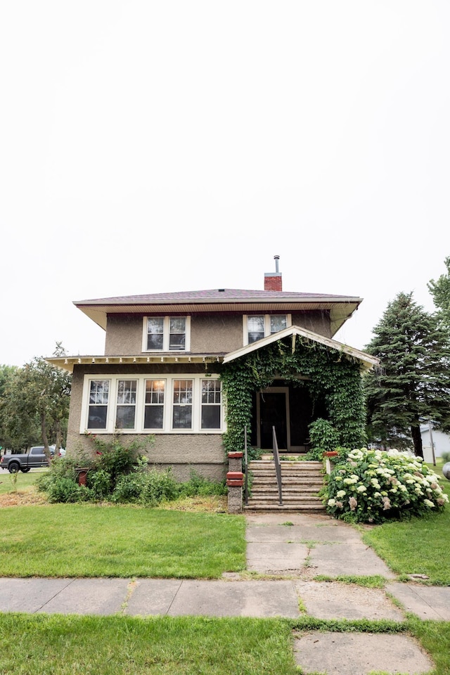 605 Chestnut St, Ellsworth, MN 56129 - view of front facade featuring a chimney, a front lawn, and stucco siding