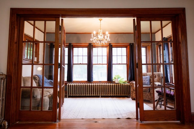 605 Chestnut St, Ellsworth, MN 56129 - doorway with radiator heating unit, a chandelier, wood finished floors, and french doors