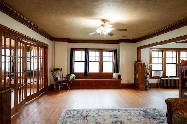 605 Chestnut St, Ellsworth, MN 56129 - living area featuring radiator, a ceiling fan, ornamental molding, wood finished floors, and a textured ceiling