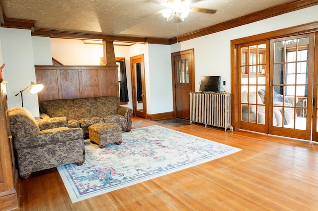 605 Chestnut St, Ellsworth, MN 56129 - living room with radiator heating unit, ceiling fan, ornamental molding, wood finished floors, and a textured ceiling