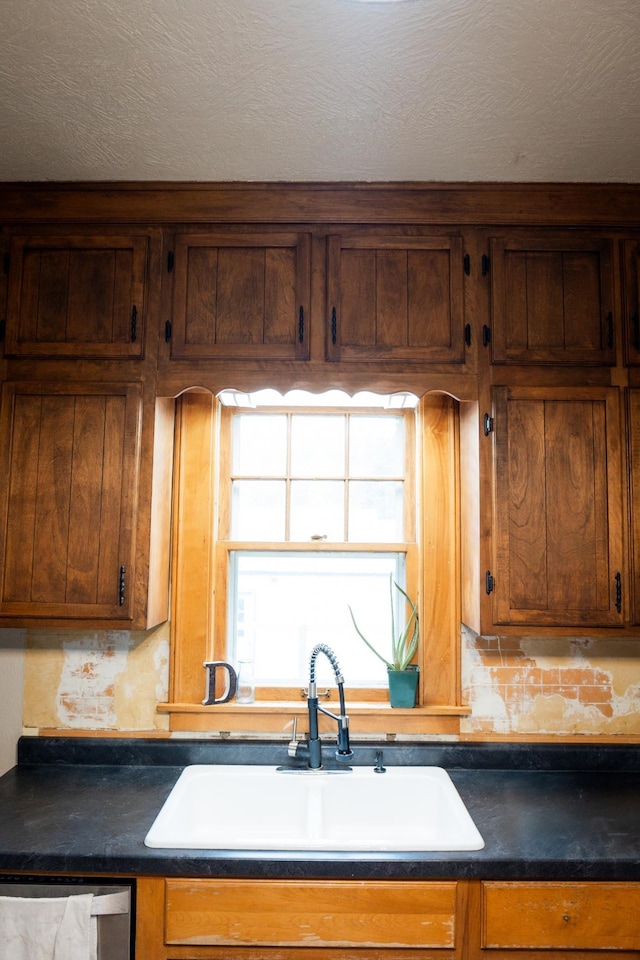 605 Chestnut St, Ellsworth, MN 56129 - kitchen with dark countertops, dishwasher, brown cabinetry, and a textured ceiling