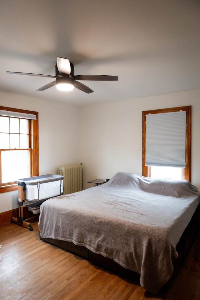 605 Chestnut St, Ellsworth, MN 56129 - bedroom with radiator, wood finished floors, and ceiling fan