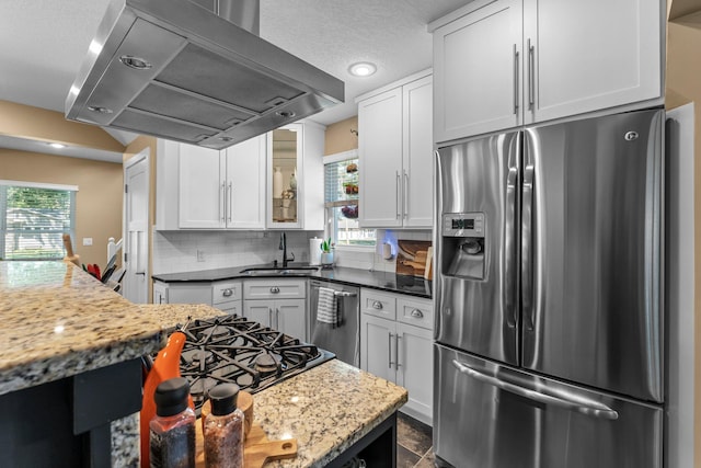 640 3rd St N, Dassel, MN 55325 - kitchen featuring appliances with stainless steel finishes, exhaust hood, tasteful backsplash, white cabinetry, and a textured ceiling