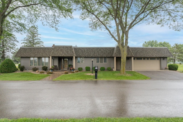 102 Terrace Vw E, Decoria Twp, MN 56001 - ranch-style home with asphalt driveway, roof with shingles, an attached garage, mansard roof, and a front lawn