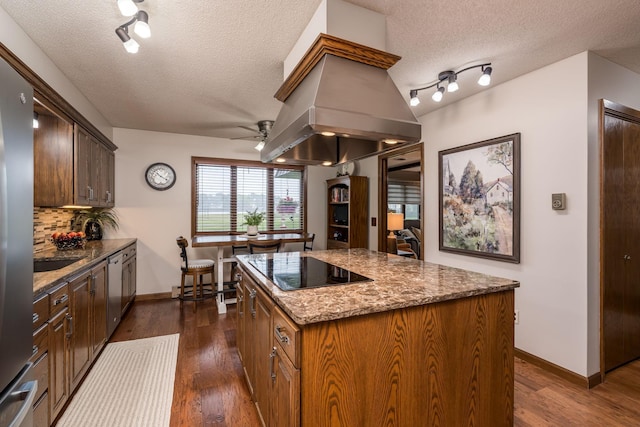 102 Terrace Vw E, Decoria Twp, MN 56001 - kitchen featuring black electric stovetop, a textured ceiling, a ceiling fan, island range hood, and a center island
