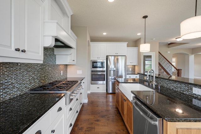 6430 Bluestem Cir, Corcoran, MN 55340 - kitchen featuring appliances with stainless steel finishes, arched walkways, tasteful backsplash, dark wood finished floors, and recessed lighting