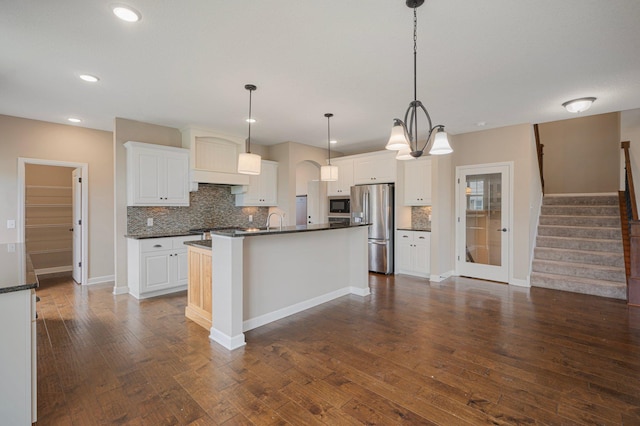 6430 Bluestem Cir, Corcoran, MN 55340 - kitchen featuring stainless steel refrigerator with ice dispenser, black microwave, decorative backsplash, dark wood finished floors, and recessed lighting
