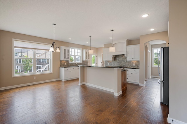 6430 Bluestem Cir, Corcoran, MN 55340 - kitchen with freestanding refrigerator, dark countertops, tasteful backsplash, glass insert cabinets, and recessed lighting