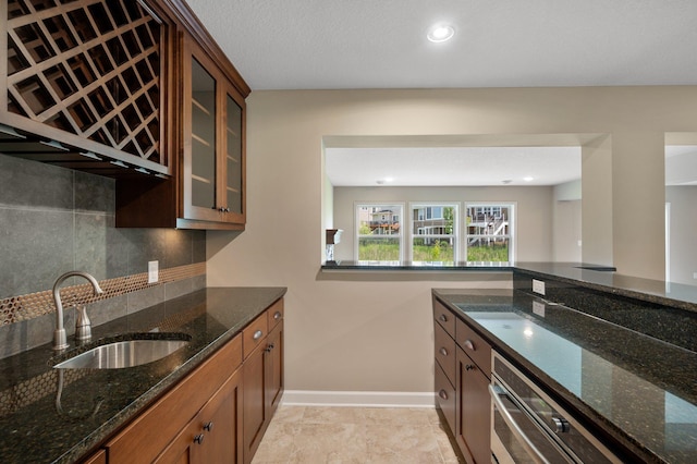 6430 Bluestem Cir, Corcoran, MN 55340 - kitchen with tasteful backsplash, dark stone countertops, glass insert cabinets, brown cabinets, and recessed lighting