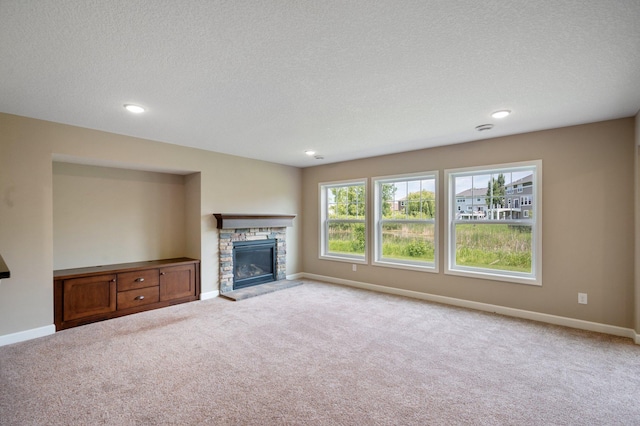 6430 Bluestem Cir, Corcoran, MN 55340 - unfurnished living room featuring carpet floors, a textured ceiling, a stone fireplace, and recessed lighting
