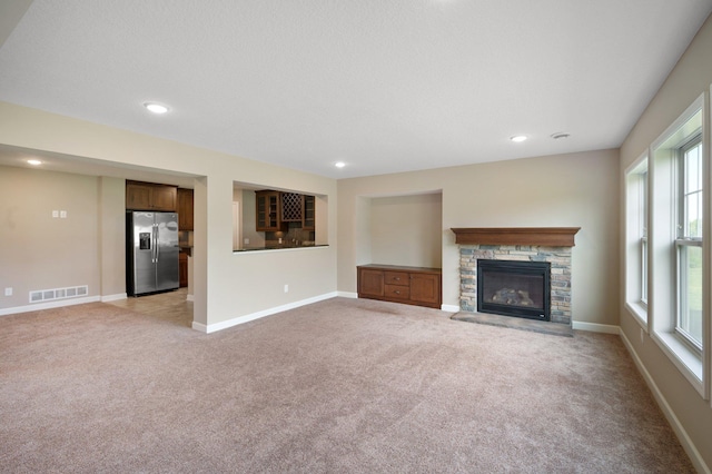 6430 Bluestem Cir, Corcoran, MN 55340 - unfurnished living room featuring light colored carpet, a stone fireplace, and recessed lighting