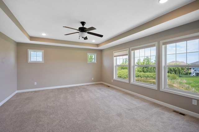 6430 Bluestem Cir, Corcoran, MN 55340 - empty room with plenty of natural light, a ceiling fan, recessed lighting, carpet flooring, and a raised ceiling