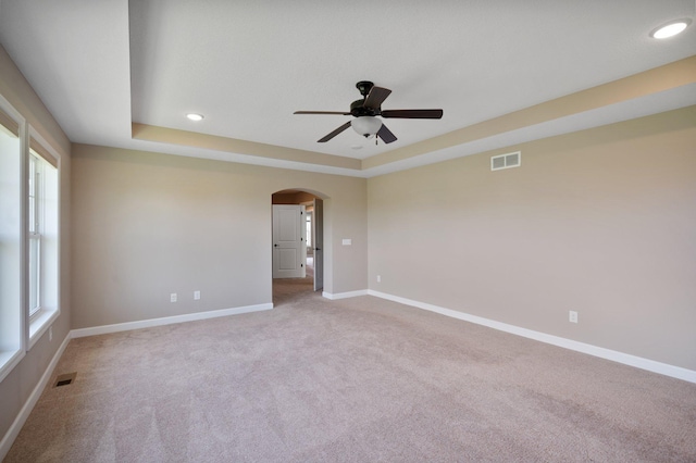 6430 Bluestem Cir, Corcoran, MN 55340 - carpeted empty room with arched walkways, a ceiling fan, a tray ceiling, and recessed lighting