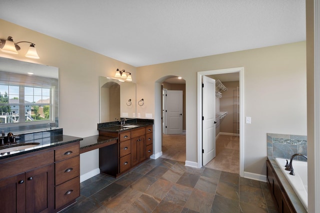 6430 Bluestem Cir, Corcoran, MN 55340 - full bath with vanity, a bath, stone finish floors, and a spacious closet