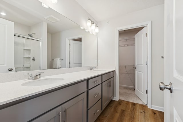 6645 Jody Ave S, Cottage Grove, MN 55016 - full bathroom featuring double vanity, wood finished floors, a shower, and a walk in closet