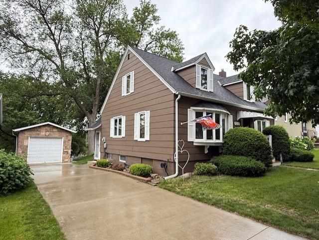 688 Miller Ave, Windom, MN 56101 - view of front of home featuring an outdoor structure, a garage, concrete driveway, and a front yard