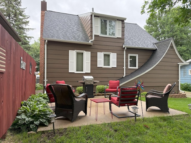 688 Miller Ave, Windom, MN 56101 - back of house featuring roof with shingles, a chimney, and a patio