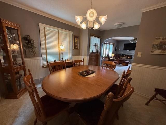 688 Miller Ave, Windom, MN 56101 - dining area featuring wainscoting, arched walkways, a chandelier, wood walls, and carpet floors