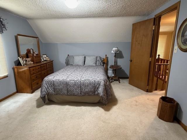 688 Miller Ave, Windom, MN 56101 - bedroom featuring light colored carpet, lofted ceiling, and a textured ceiling