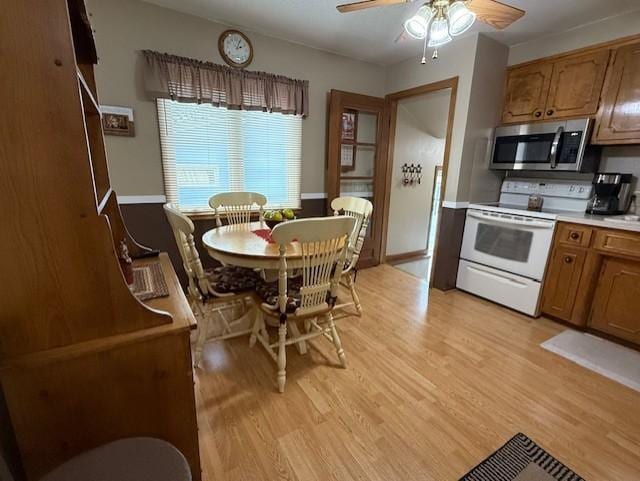 688 Miller Ave, Windom, MN 56101 - kitchen with electric range, stainless steel microwave, a ceiling fan, light wood-type flooring, and light countertops