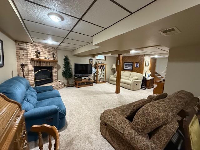 688 Miller Ave, Windom, MN 56101 - carpeted living area with a drop ceiling, stairs, and a fireplace