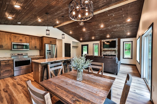 19566 Early Bird Dr, Park Rapids, MN 56470 - dining room featuring vaulted ceiling, healthy amount of natural light, wood ceiling, light wood-type flooring, and a fireplace
