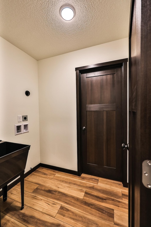 19566 Early Bird Dr, Park Rapids, MN 56470 - laundry room with washer hookup, hookup for an electric dryer, light wood-style flooring, and a textured ceiling