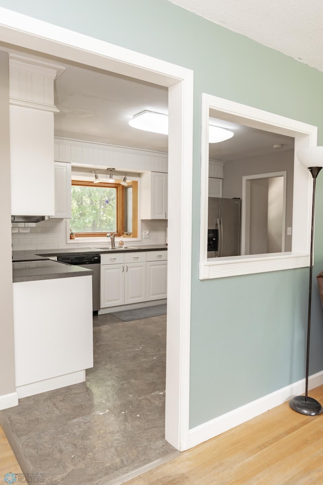 420 17th St S, Moorhead, MN 56560 - kitchen with stainless steel appliances, white cabinetry, dark countertops, and backsplash