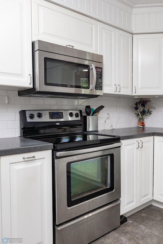 420 17th St S, Moorhead, MN 56560 - kitchen featuring appliances with stainless steel finishes, white cabinetry, dark countertops, and tasteful backsplash