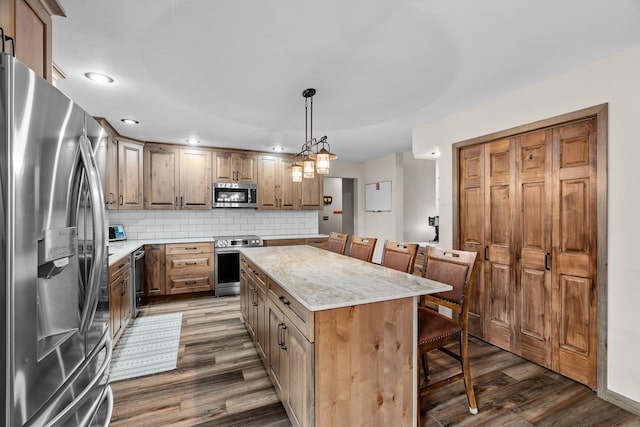 876 162nd St, Hammond, WI 54015 - kitchen featuring stainless steel appliances, a kitchen breakfast bar, wood finished floors, a kitchen island, and backsplash
