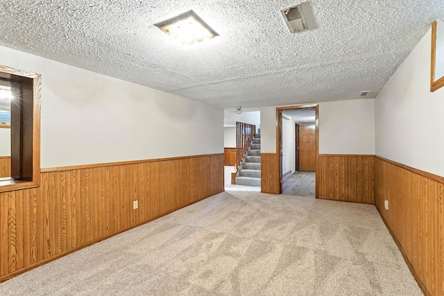 11439 Heights Dr NW, Coon Rapids, MN 55433 - carpeted spare room with a wainscoted wall, a textured ceiling, wood walls, and stairs