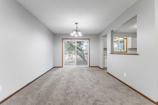 11460 Goldenrod St NW, Coon Rapids, MN 55448 - unfurnished dining area with a chandelier, light carpet, and a textured ceiling