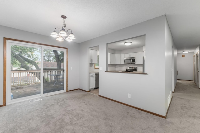 11460 Goldenrod St NW, Coon Rapids, MN 55448 - kitchen featuring appliances with stainless steel finishes, light colored carpet, white cabinetry, a chandelier, and hanging light fixtures