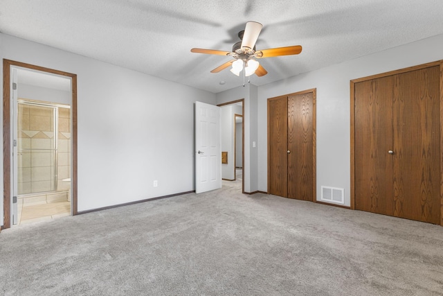 11460 Goldenrod St NW, Coon Rapids, MN 55448 - unfurnished bedroom featuring carpet floors, two closets, ensuite bath, a ceiling fan, and a textured ceiling