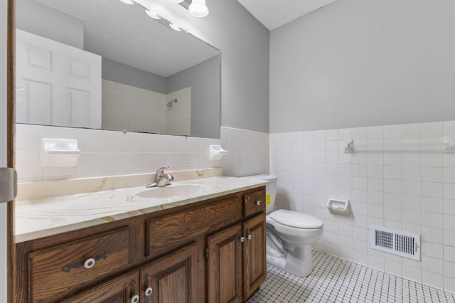 11460 Goldenrod St NW, Coon Rapids, MN 55448 - bathroom featuring tile walls, vanity, tile patterned flooring, wainscoting, and a shower
