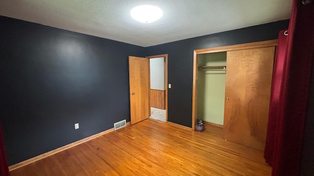 122 Plainview Ave, Mankato, MN 56001 - unfurnished bedroom featuring wood finished floors, a closet, and a textured ceiling