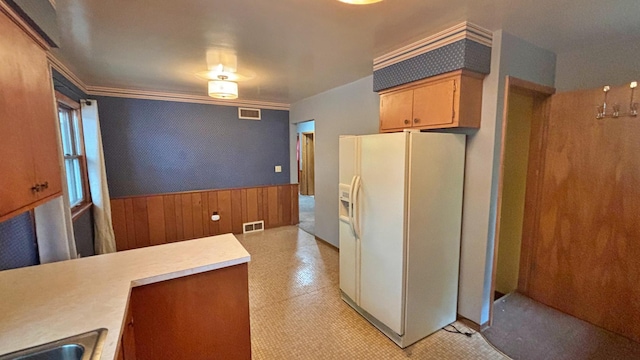 122 Plainview Ave, Mankato, MN 56001 - kitchen featuring white fridge with ice dispenser, wainscoting, light countertops, wooden walls, and light floors