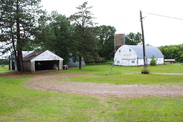 34497 Quiken Rd, Motley, MN 56466 - view of green lawn featuring a garage, an outbuilding, a barn, and dirt driveway