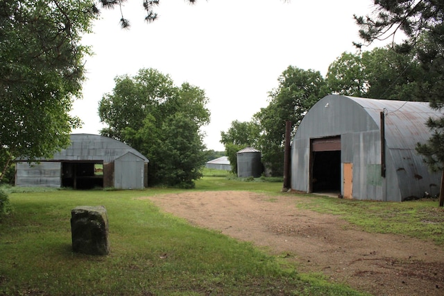34497 Quiken Rd, Motley, MN 56466 - view of grassy yard with an outbuilding, a pole building, a detached garage, and driveway