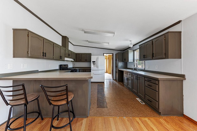 108 Hilton Ct, Mankato, MN 56001 - kitchen featuring white refrigerator with ice dispenser, stainless steel range with gas stovetop, a peninsula, under cabinet range hood, and light countertops